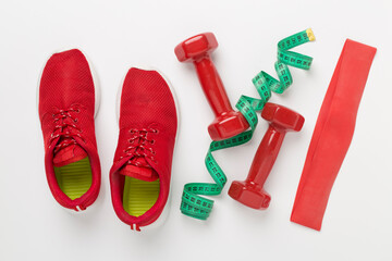 Sport equipment with tape measure on color background, top, view. Weight loss concept