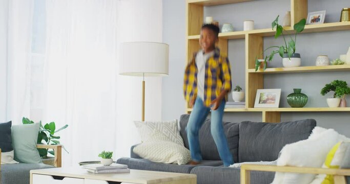 Boy, child and sofa jump fun in home for happy morning, holiday energy or joy moving. Black person, bounce or adhd active on furniture or excited dance or play, crazy vacation or wild games on couch