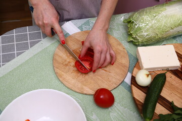 Woman cutting red tomatoes in kitchen