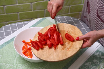 Woman cutting red tomatoes in kitchen