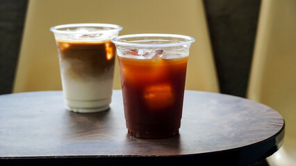 iced latte and ice americano coffee on a wooden table, Summer drinks background. Iced drink and iced coffee in to go glass. Coffee shop or cafe and restaurant.