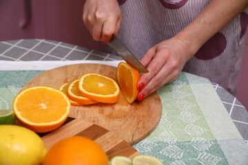 Obraz na płótnie Canvas A person cutting oranges on a cutting board