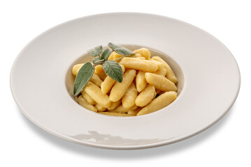 Ravioles de Melle topped with butter and sage sauce, typical gnocchi from Val Varaita, Piedmont, Italy made with potatoes, flour and cheese. Raw gnocchi in dish isolated 