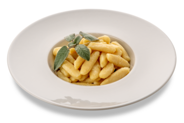 Ravioles de Melle topped with butter and sage sauce, typical gnocchi from Val Varaita, Piedmont, Italy made with potatoes, flour and cheese. Raw gnocchi in dish isolated 