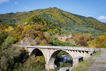 Fototapeta na wymiar Elevated Bridge Over a River Amidst the Majestic Mountain Landscape