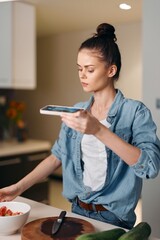 Indoor Communication: Pretty Caucasian Lady Using Wireless Smartphone for Texting in Modern Kitchen