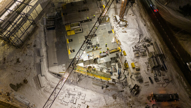 Drone photography of construction site and construction workers working during winter night