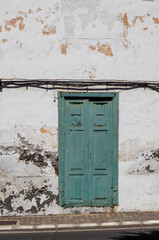 Peeled off wall of a house with green door