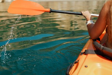 Kayak paddle sea vacation. Person paddles with orange paddle oar on kayak in sea. Leisure active lifestyle recreation activity rest tourism travel - obrazy, fototapety, plakaty