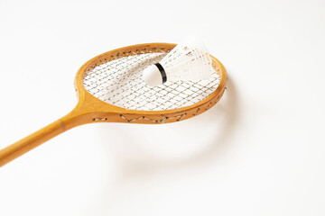 Old wooden racket and shuttlecock closeup on a white background, sport