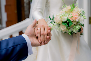 Obraz na płótnie Canvas Crop newlyweds holding hands during wedding