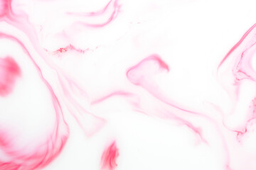Background with red streaks on white milk. Marble texture.