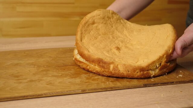 A freshly baked cake is cut in half. Cooking a festive pie at home. Slow motion.