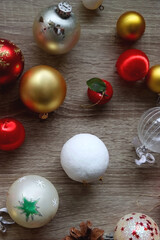 Pine cones and red, golden and white Christmas ornaments on wooden background. Top view.
