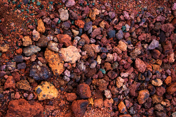 Red and pink rough volcanic stones in a quarry in Iceland. Textured background