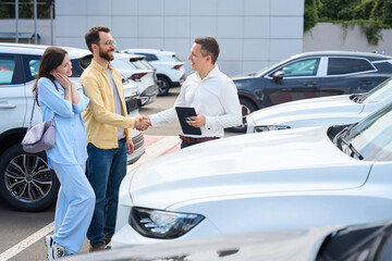 Car dealership employee communicates with customers before a test drive