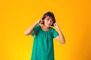 Girl ignoring stressful environment, closed ears with hands - obrazy, fototapety, plakaty
