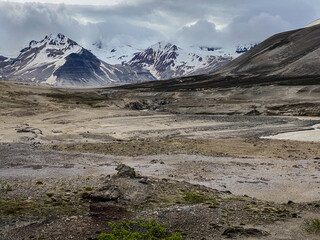River flowing through The Valley of Ten Thousand Smokes in Katmai National Park and Preserve in Alaska. Valley between mountains is filled with ash flow from Novarupta eruption in 1912. Erosion of ash
