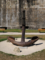 	Big old marine anchor in front of the ramparts of the fortified city of Saint Malo. Saint-Malo is a walled port city in Brittany in northwestern France on the English Channel