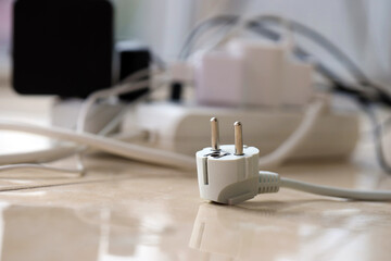 Overloaded power boards. Power strips with different electrical plugs on white floor. Concept of risk danger overloaded current electrical