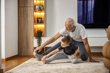 A grandson and grandad doing yoga at home.