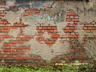 Old house wall with broken plaster parts and visible red bricks. Abstract background pattern of a...