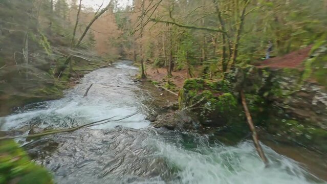 fpv drone flying between rocks above waterfalls on Ognon river Vosges region