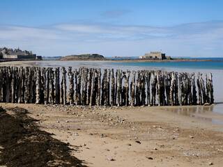 Sillon beach of Saint Malo and its oak pile breakwaters. We can see Fort National in the distance. Saint-Malo is a French commune located in Brittany