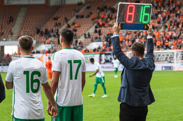 Team manager man shows players substitution during football match.