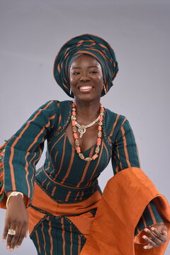 Excited Smiling Happy Young black African Nigerian Yoruba looking gorgeous wearing native attire dancing motion 