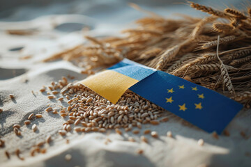 Wheat grains scattered on a white surface with flags. The Ukrainian flag on the left and the European Union flag on the right suggest an agricultural partnership - obrazy, fototapety, plakaty
