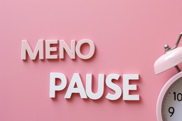 The concept of menopause creatively depicted by a white alarm clock against a soft pink background, along with the word 'MENOPAUSE' separated by a pause symbol