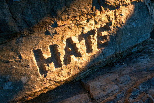 Carved deep into stone, the word 'HATE' remains indelible