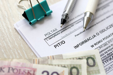 Information about deductions from income and tax, PIT-O form on accountant table with pen and polish zloty money bills close up