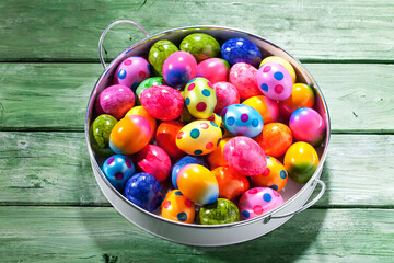 Tray of coloured Easter eggs on green wood