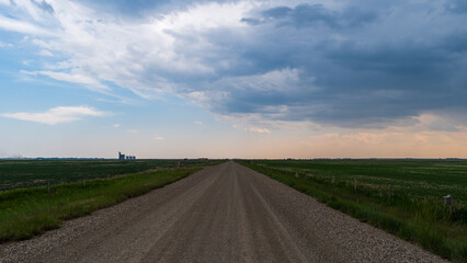 Dirt road leads into thunderstorm over Alberta Prairie