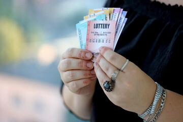 Woman hands with indian rupees bills and lottery ticket close up. Concept of gambling and winning...