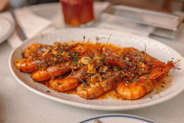 Tasty delicious roasted Grilled king prawns, shrimps with sauce and lemon on a plate in restaurant