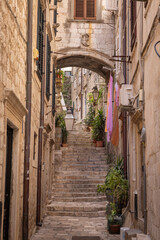 The medieval city of Dubrovnik, Dalmatia, Croatia. Narrow street with a staircase and an arch.