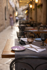 A table in a mediterranean restaurant set for dinner. Reserved marker on the table, shallow depth of field. Dubrovnik, Croatia