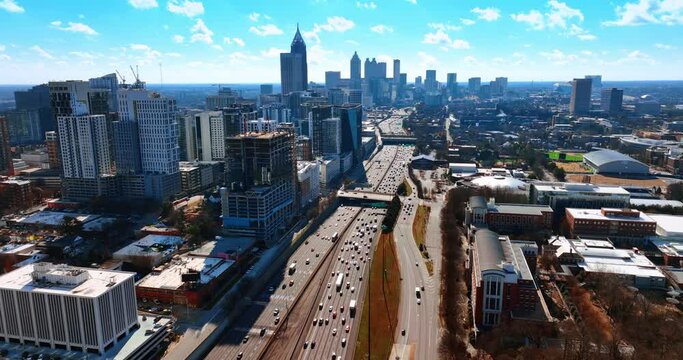 Sunny bright day in Atlanta, Georgia, USA. Drone footage of a cityscape over the busy highway.