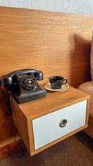 old tea cup with old phone on bedside table