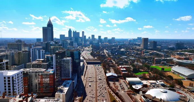 Wide multi-lane road going along Atlanta downtown. Scenic view of American metropolis on sunny day from top.
