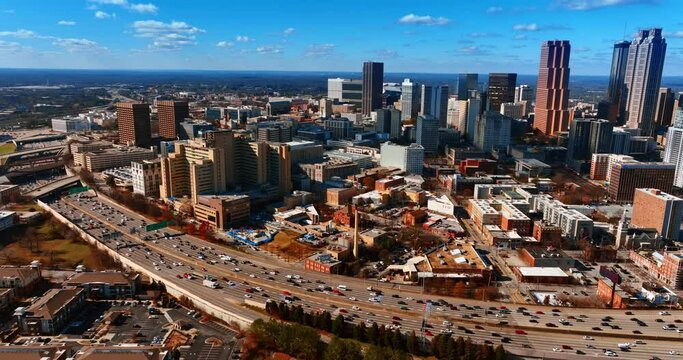 Multiple cars in the road going around the city downtown. Splendid view of Atlanta from aerial perspective.