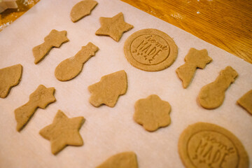Christmas and New Year celebration traditions. Traditional festive food making, family culinary. Woman cutting cookies of raw gingerbread dough. High quality photo