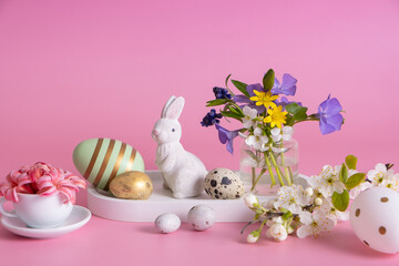 White rabbit, flowers and Easter eggs on a pink background and Easter eggs on a pink background