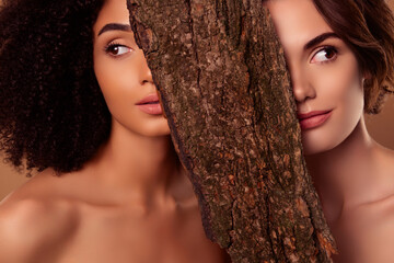 Photo of attractive gentle girls cover with tree bark advertising modern technology eco bodycare...