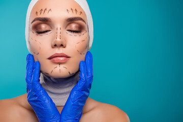 Photo of lady with drawing correction marks on face touch by doctor prepare for beauty operation over cyan background