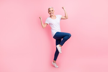 Full body photo of optimistic senior person dressed stylish t-shirt denim pants win bet clenching fists isolated on pink color background - obrazy, fototapety, plakaty