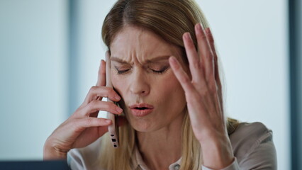 Stressed entrepreneur calling phone at workroom. Confused manager facepalming